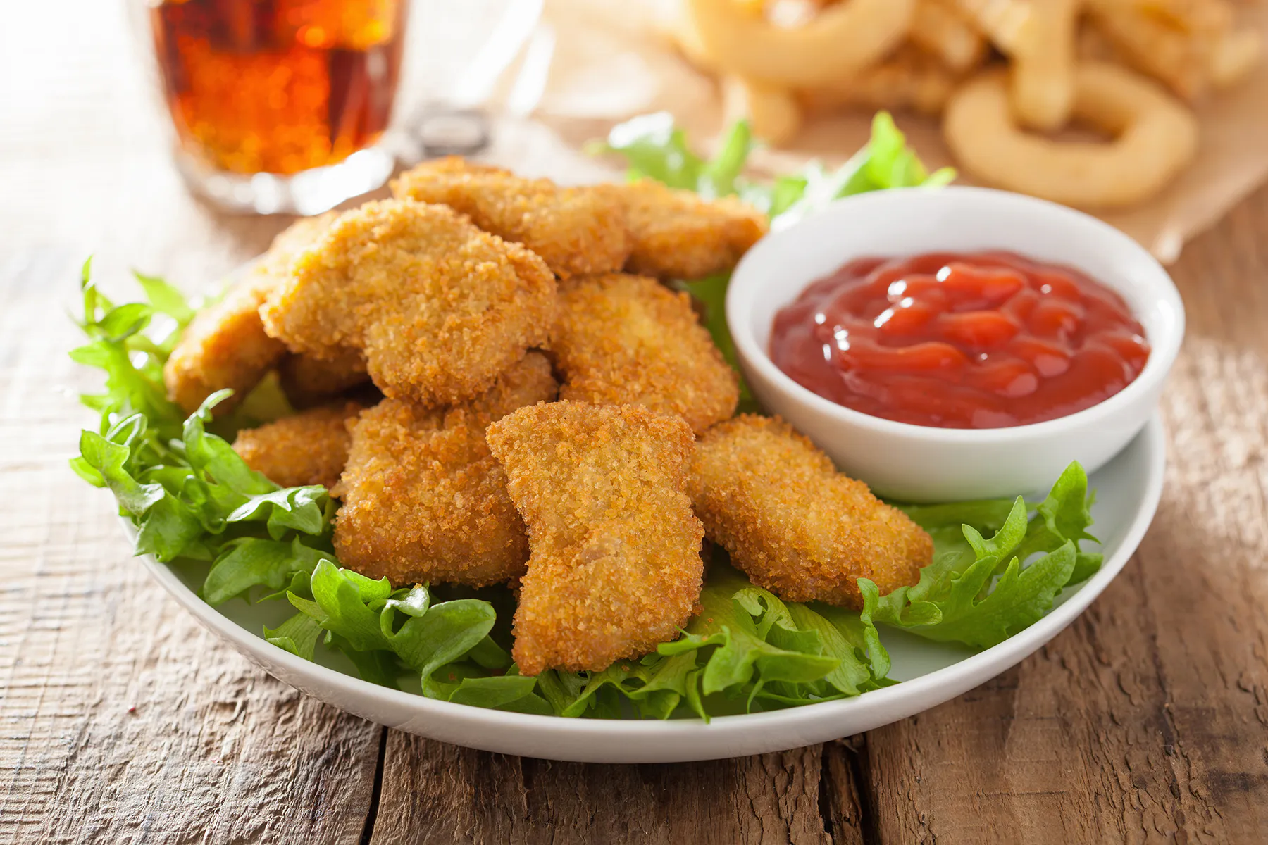 Breaded chicken bites with ketchup and fresh lettuce